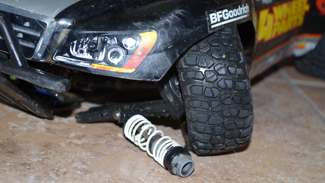 Broken front lower control arm and exploded UltraShock damper